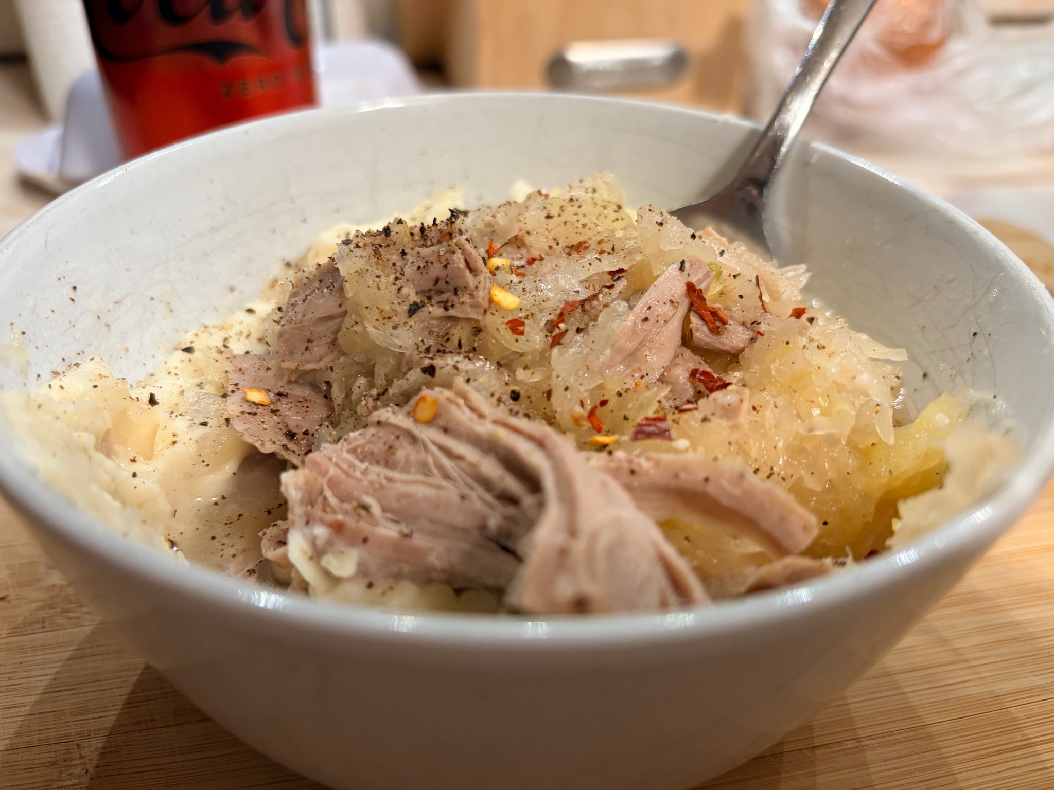A bowl of pork and sauerkraut served over mashed potatoes
